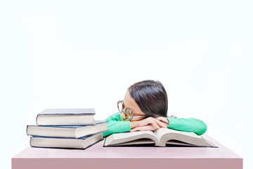 Asian cute girl with glasses fall asleep on book on the desk