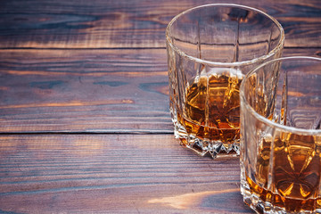 Two glasses of whiskey on a wooden table