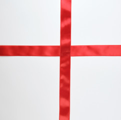 Fototapeta premium red satin ribbon cross to cross on white background