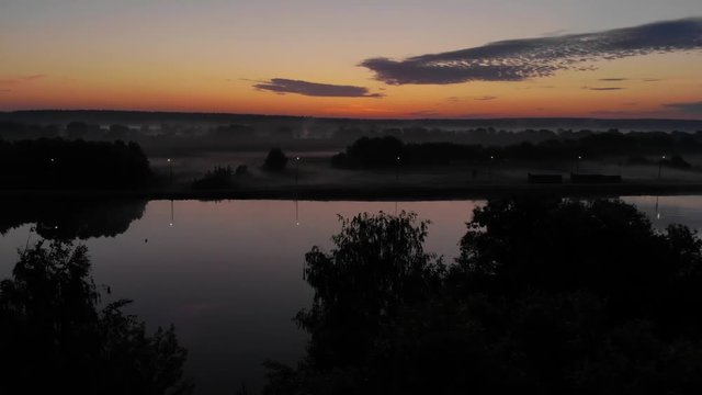 Foggy sunrise above lake, drone footage