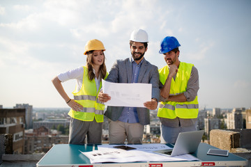 Architects, business manager and engineer meeting project at building site