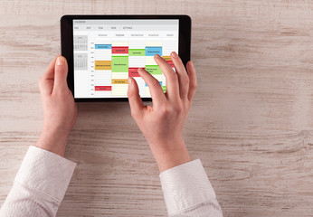 Hand holding tablet with timetable and calendar concept

