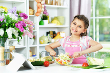 Portrait of cute little girl preparing fresh salad