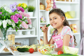 Obraz na płótnie Canvas Portrait of cute little girl preparing fresh salad