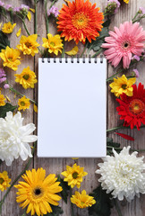 Obraz premium Colorful chrysanthemums placed on the table old wooden with book diary for text
