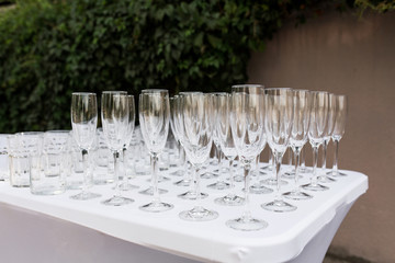 Many empty clean glasses for guests at the buffet festive wedding table
