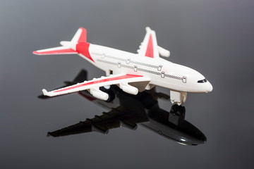Model plane, airplane isolated on black mirror.