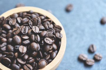 Roasted coffee beans on wooden bowl background