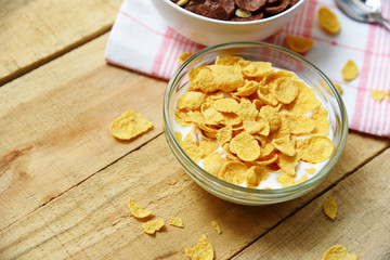 Cornflakes in bowl with milk on wooden background for cereal healthy breakfast