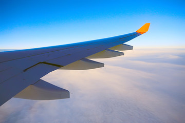 Fototapeta na wymiar wing airplane view of sky / blue sky and wing of an airplane, view from the cabin of an airplane, concept of air transport