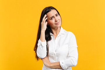 Portrait of displeased tired young woman in white casual shirt looking camera, putting hand on head...