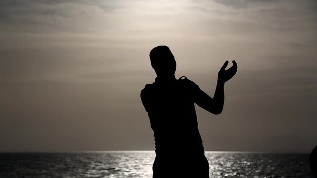 A man in a joyful mood dancing on a ship at sea