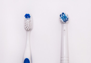 Cepillo de dientes manual y cepillo de dientes eléctrico sobre fondo blanco.