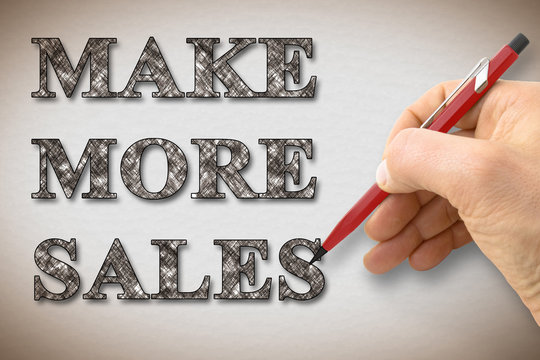 Hand writing "Make More Sales" on a blank card - concept image