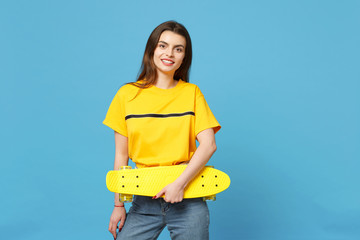Portrait of cheerful young woman in vivid casual clothes standing, looking camera, holding yellow...