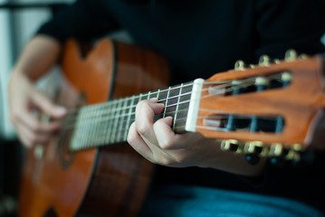 Fototapeta premium woman's hands playing acoustic guitar, close up