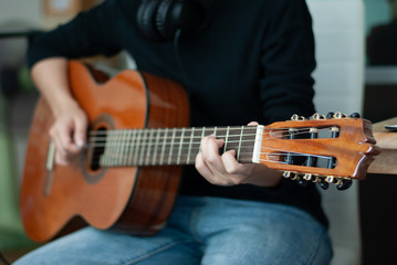 Fototapeta na wymiar woman's hands playing acoustic guitar, close up