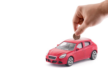 Putting coin into the car coin bank on white background 