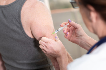 Doctor injecting vaccine to patient