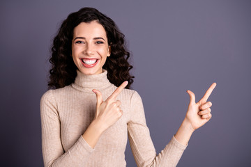 Obraz premium Portrait of her she nice attractive charming cute cheerful glad positive confident content wavy-haired lady pointing two forefingers ad advert isolated on gray pastel background