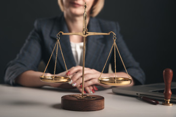 Woman with notary books in office. Wooden gavel with libra and laptop concept