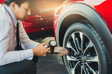 Asian man car inspection Measure quantity Inflated Rubber tires car.Close up hand holding machine Inflated pressure gauge for car tyre pressure measurement for automotive, automobile image © TECHNOLOGY FACTORY