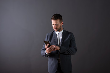 A serious businessman using his smartphone