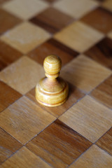 White pawn on a chessboard, isolated, closeup