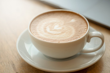 A cup of coffee on desk, Cup of coffee in hand, mug of latte coffee, Close up concept.