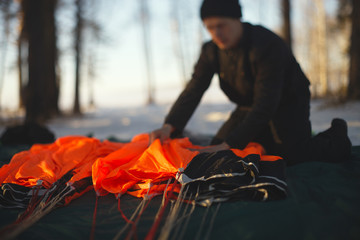 Base jumper packing the parachute before jumping close-up. Parachute equipment. Tilt-shift effect.