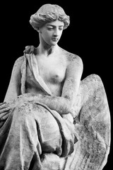 Antique stone statue of an angel isolated on black background.
