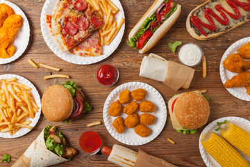 Mix of fast food, street dishes. Background with copy space. Top view. Natural wooden background.