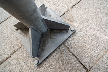 Metal pillar attached to stone blocks with bolts