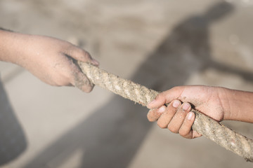 Closeup of a hands pulling a rope. concept of teamwork, rival and effort