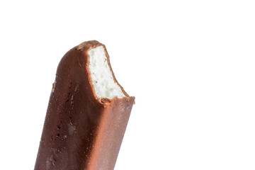 Bitten ice cream lolly in chocolate glaze close-up with condensate isolated on a white background.