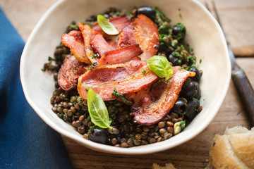 Brown lentils with spinach, black olives and fried bacon 