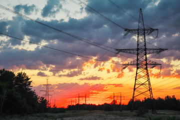 Silhouette High voltage electric towers at sunset time. High-voltage power lines. Electricity distribution station