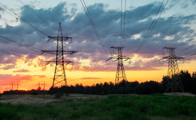 Silhouette High voltage electric towers at sunset time. High-voltage power lines. Electricity distribution station