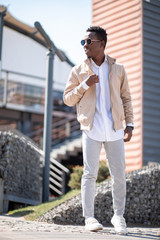 Handsome black young man in a jacket and white shirt on the street. Businessman