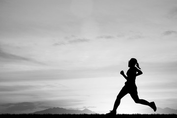 silhouette Young woman running on blurry sunset