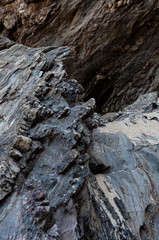 Surface of rocky wall with different hardnesses where the parts of the hardest rock stand out, forming slienties. Can be used as background.