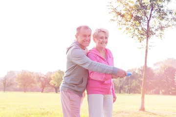Loving active couple throwing flying disc together in park