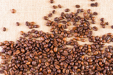 Coffee beans on a background of burlap. Place for text. Concept of making coffee, coffees.