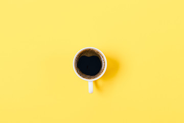 One coffee cup in center of bright yellow background