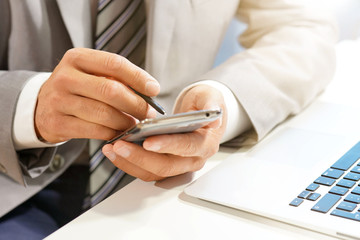 Close up of businessman's hands using stylus pen on cellphone
