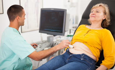 Man sonographer examining female patient