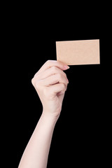 Young asia clean girl hand holding a blank kraft brown paper card template isolated on black background, clipping path, close up, mock up, cut out