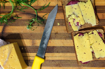 Chopping board with knife, sandwich and greens