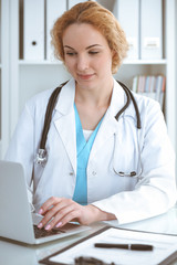 Doctor woman at work. Physician typing on laptop computer. Medicine, healthcare concept