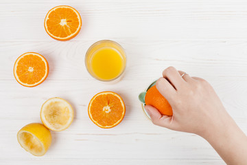 Hand making orange juice